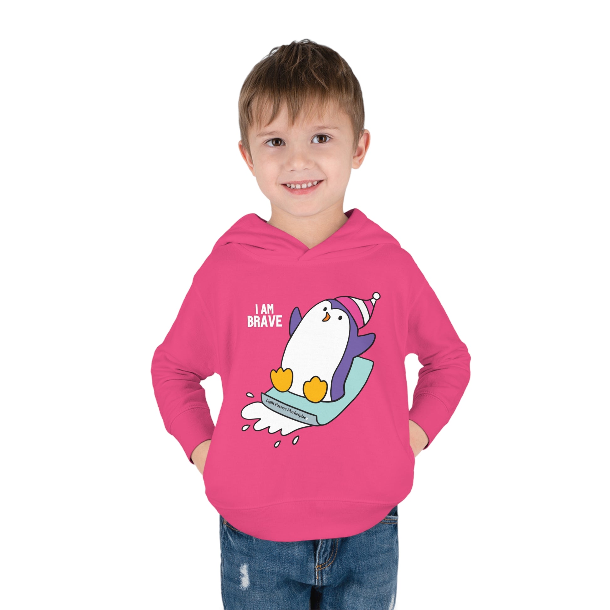 A toddler in a pink hoodie with a penguin design, showcasing cover-stitched details and side seam pockets for durability and comfort.