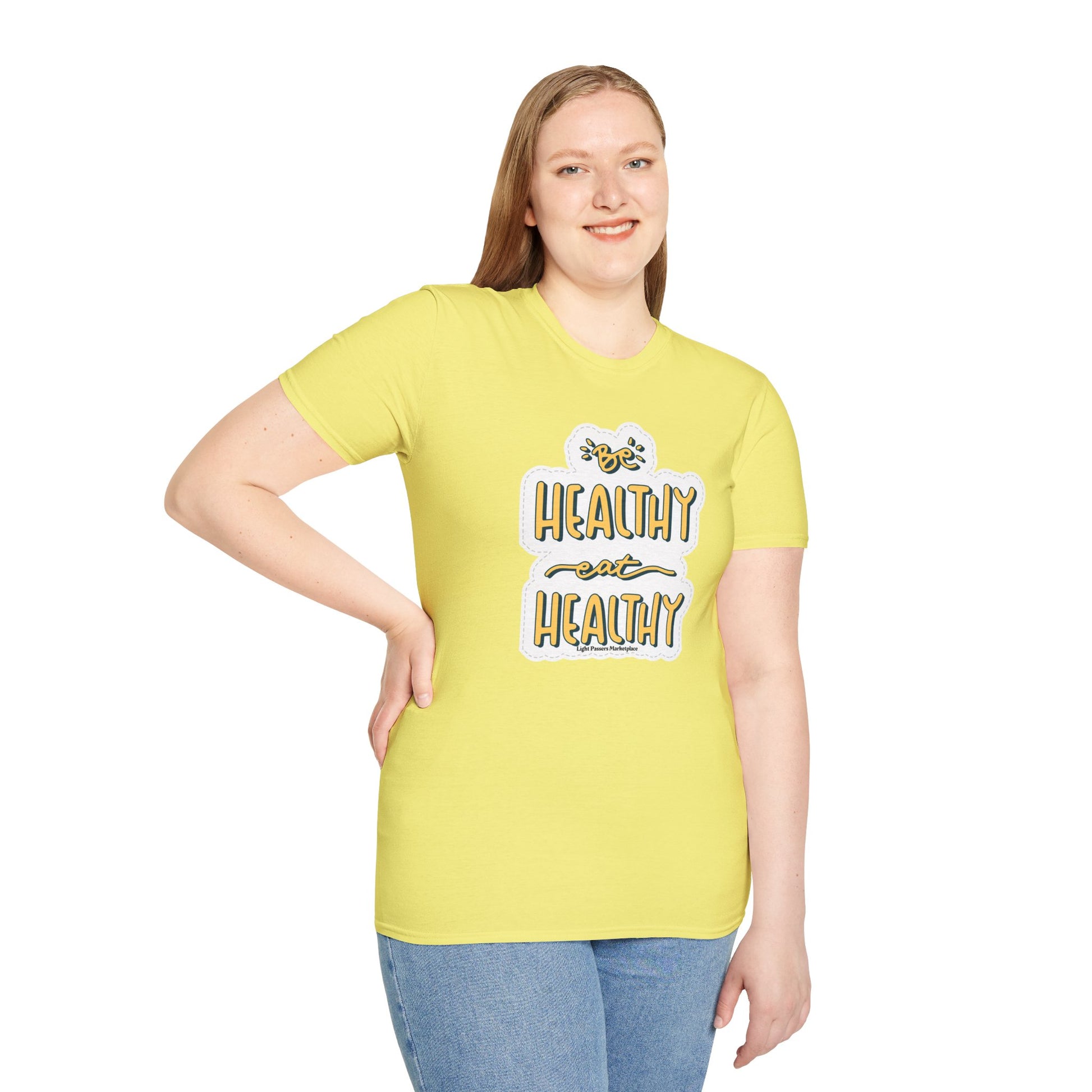 A woman in a yellow shirt poses, showcasing the Be Healthy Eat Healthy Unisex T-Shirt. Soft 100% cotton, twill tape shoulders, no side seams, ribbed collar. Versatile, classic fit tee.