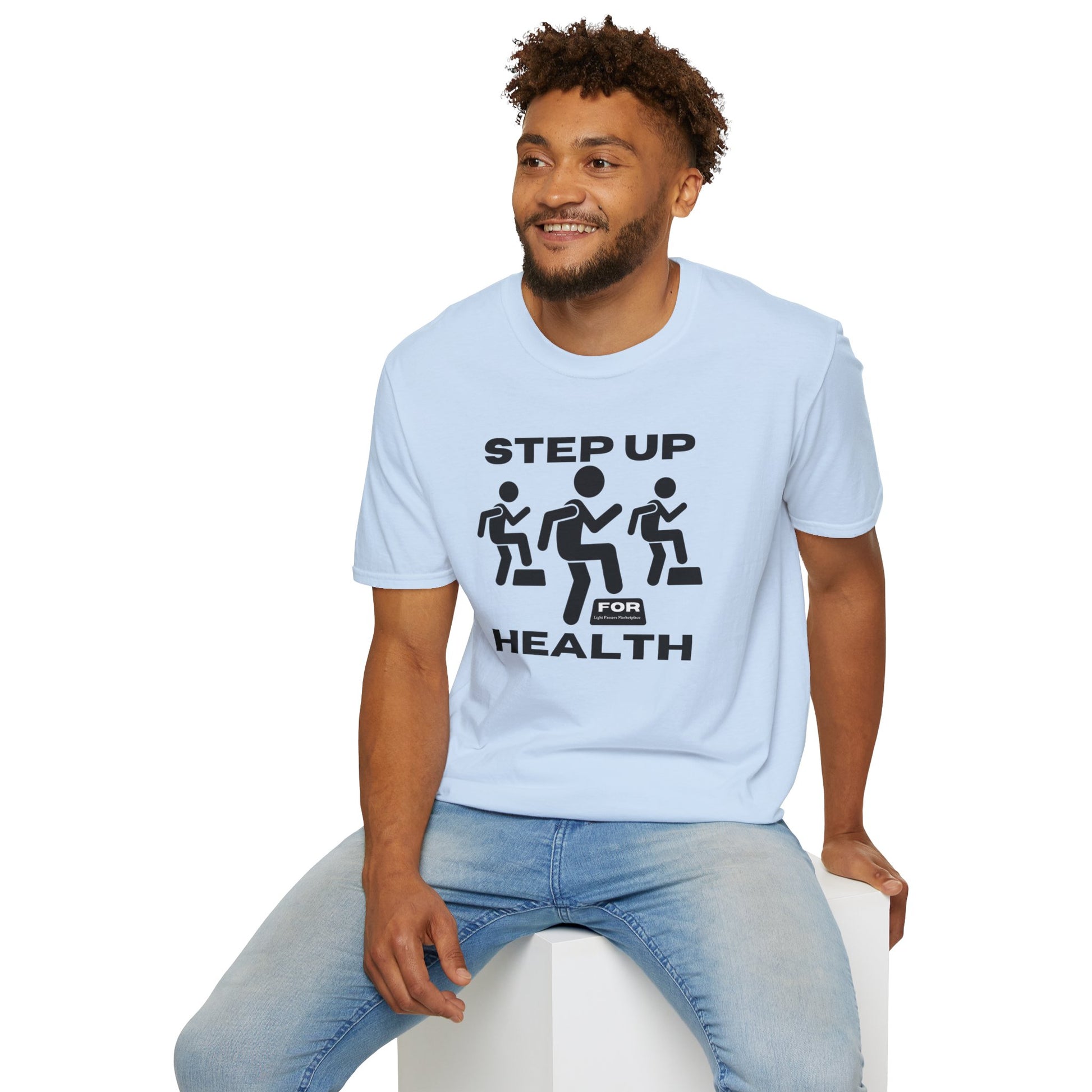 A man in a Step Up For Health unisex t-shirt, sitting on a cube, showcasing the tee's soft 100% cotton fabric, twill tape shoulders, and ribbed collar for durability and comfort.