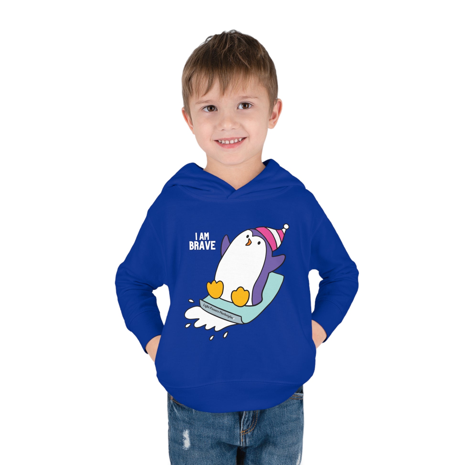 A toddler in a Rabbit Skins hoodie with a penguin design, showcasing jersey-lined hood, cover-stitched details, and side seam pockets for lasting comfort and durability.