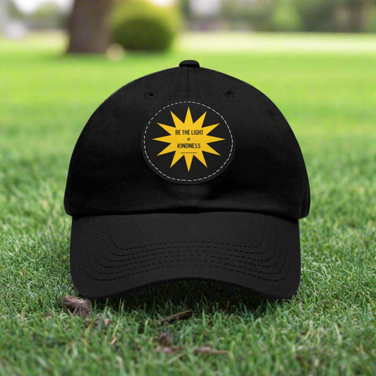 Unisex baseball style hat with 'Be the Light of Kindness' on a yellow star PU leather patch, featuring a buckle closure and durable chino twill fabric.