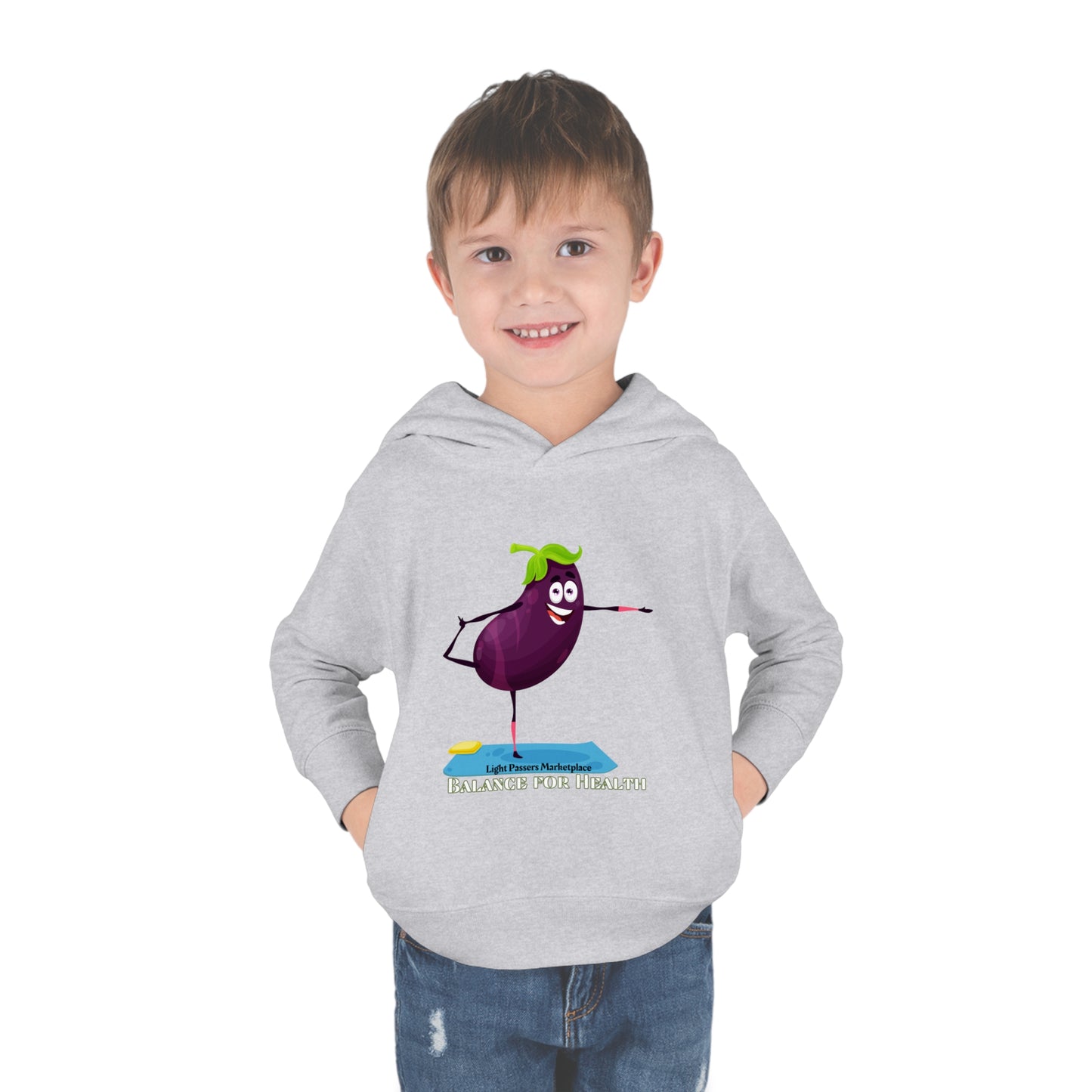 Toddler in grey hoodie with cartoon eggplant design, smiling with hands in pockets. Features jersey-lined hood, cover-stitched details, side seam pockets for cozy comfort.