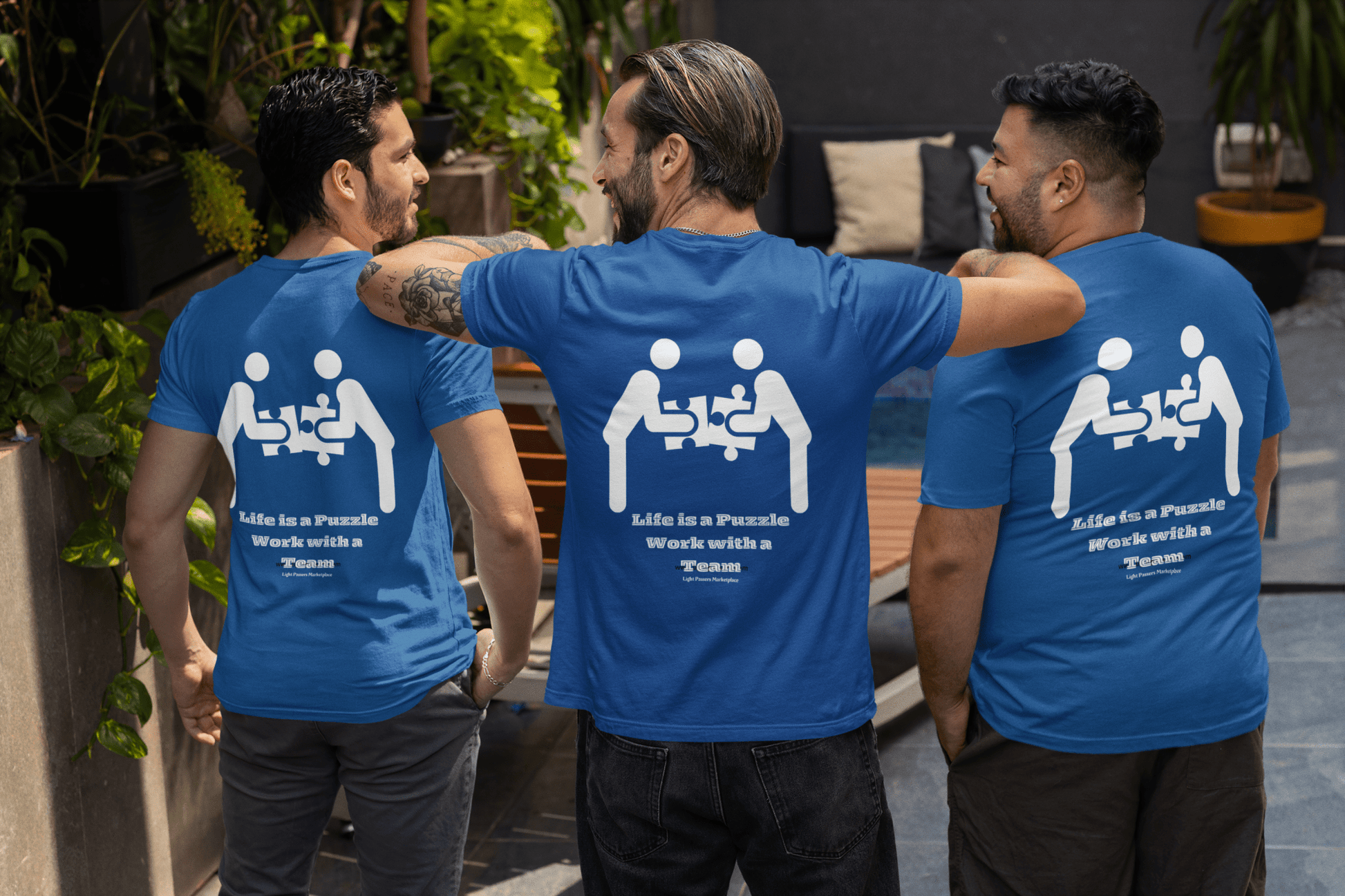 A group of men in blue shirts with white text, one with a tattoo, showcasing the Life is a Puzzle Unisex T-shirt Back. Classic fit, 100% cotton, tear-away label.