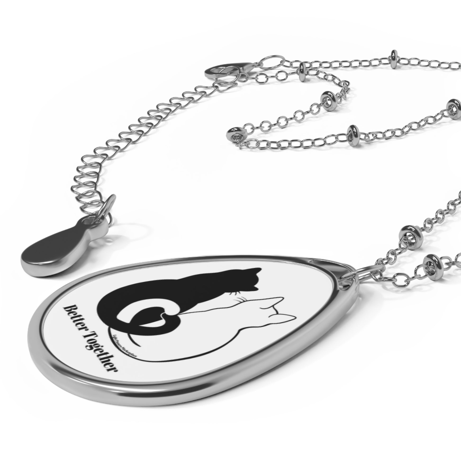 Silver necklace with ellipse pendant, featuring 'Better Together 2 Cats Love Tails', perfect for cat lovers. Glossy finish, secure lobster clasp, ideal accessory.