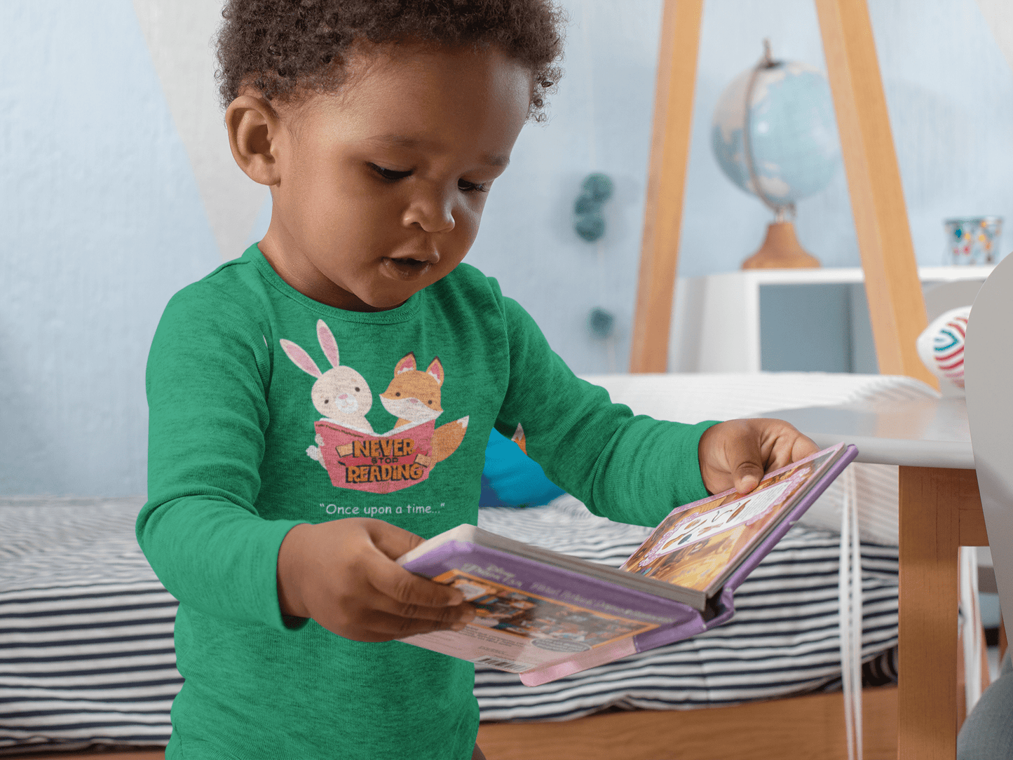 Toddler in green Never Stop Reading tee with bunnies, exploring a cozy playroom. Perfect for inspiring young readers.
