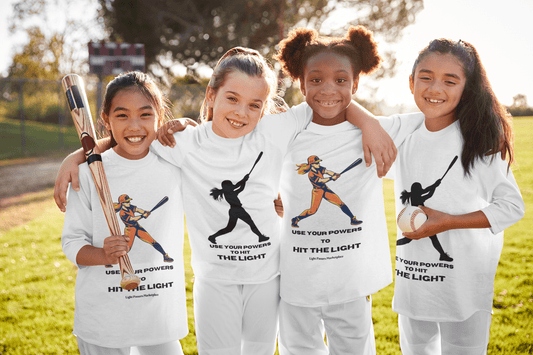 A group of girls in matching shirts, one holding a baseball bat, showcasing the Sport-Tek PosiCharge ® Competitor™ tee for active kids. Made of 100% moisture-wicking polyester, lightweight and breathable.