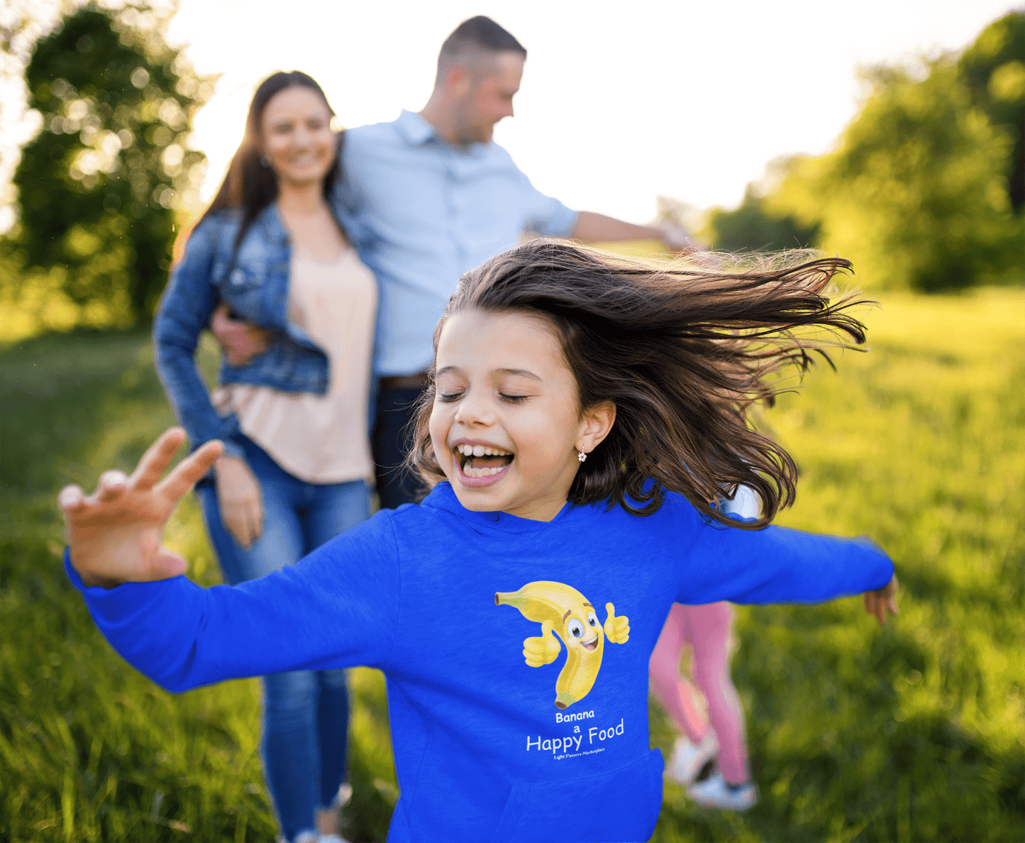 A toddler hoodie featuring a girl with hair blowing in the wind and a banana on it, embodying happiness. Jersey-lined hood, side pockets, and durable stitching for lasting coziness.