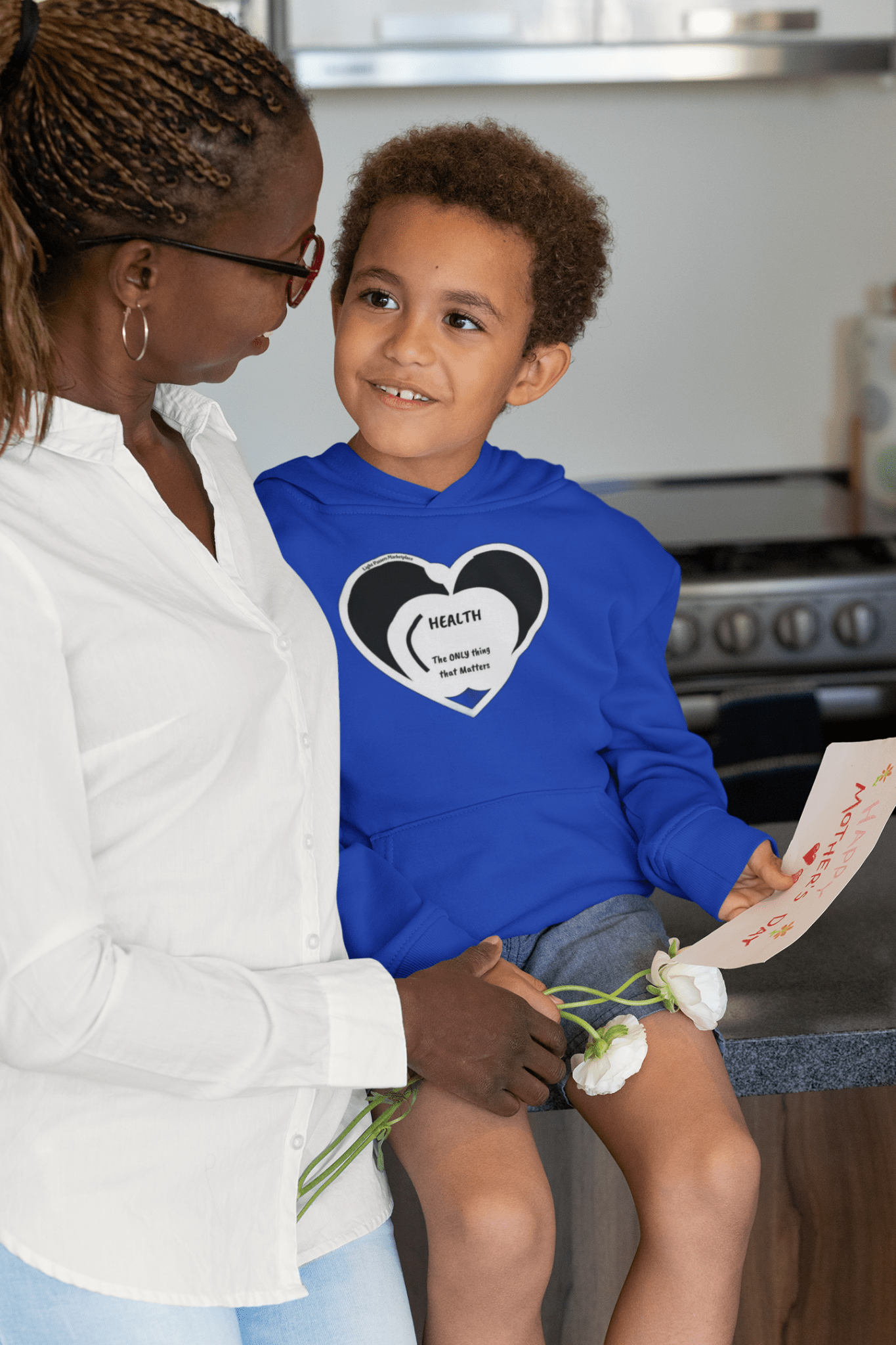 A woman holding a child in a Rabbit Skins personalized toddler hoodie with jersey-lined hood, cover-stitched details, and side seam pockets for cozy durability.