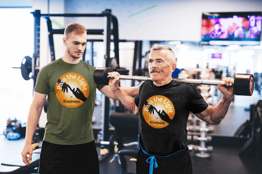 A man lifts a barbell on a Golden Ball Pass the Light Unisex T-shirt. Sporty and durable, this 100% cotton tee offers a classic fit with smooth, premium printing surface.