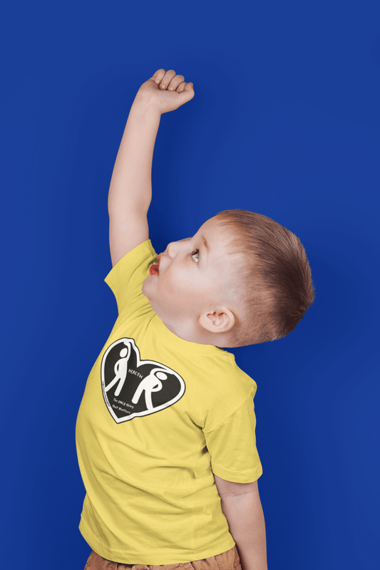 A toddler in a yellow tee with a heart design, raising his hand. Soft, durable 100% combed cotton, tear-away label, classic fit, perfect for sensitive skin.