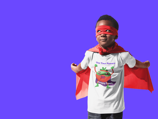 A toddler wearing a Tomato Power Toddler T-shirt with a red cape, featuring a durable print on soft cotton fabric, perfect for sensitive skin.