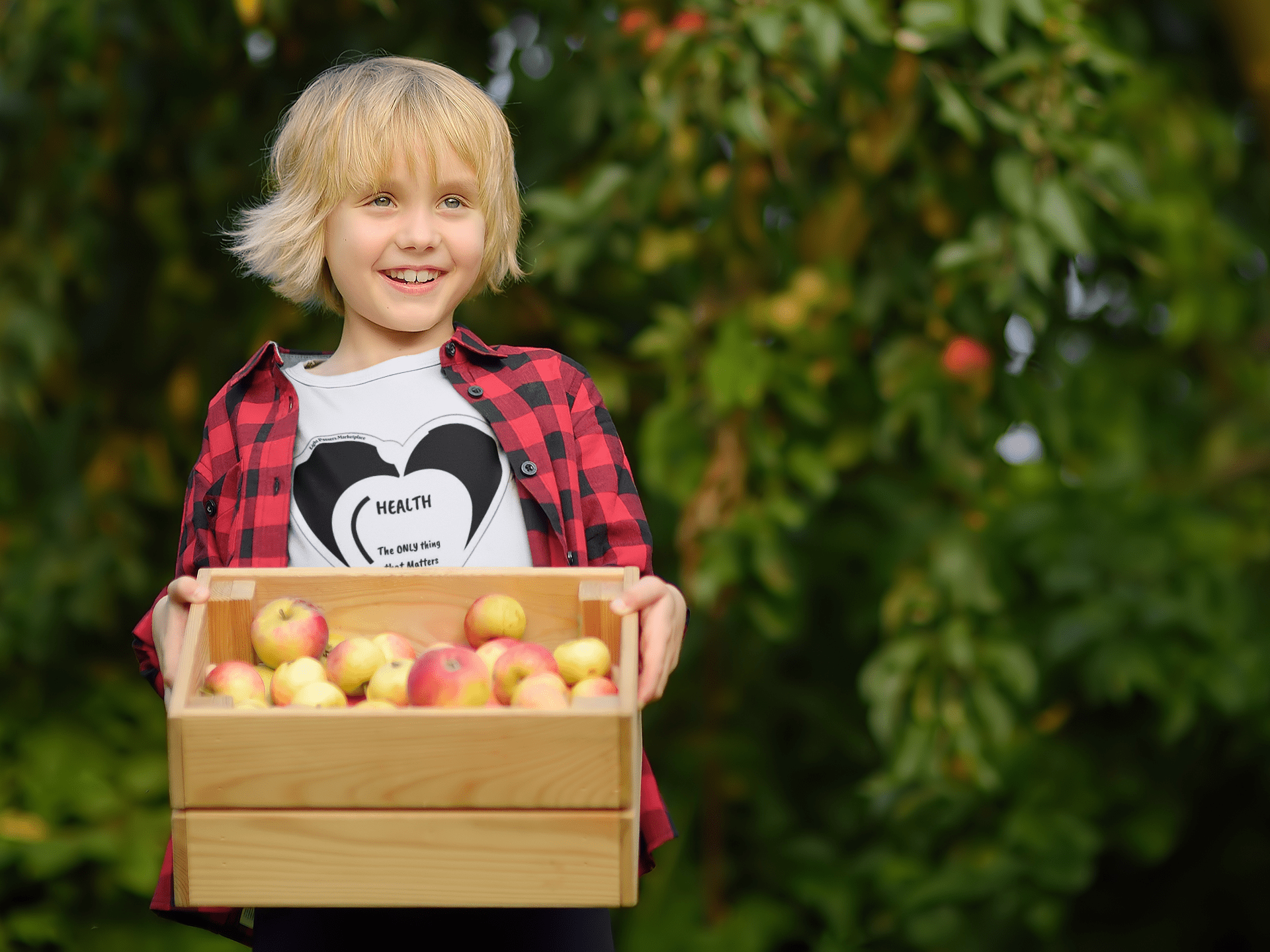 A toddler happily holds a box of apples on a soft, durable tee. Made of 100% combed cotton, light fabric, tear-away label, and a classic fit.