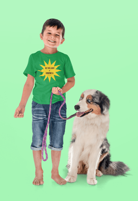 A boy holds a leash next to a dog on a green surface. A close-up of a smiling boy and a dog sitting. Light of Kindness yellow star Youth Cotton T-shirt.