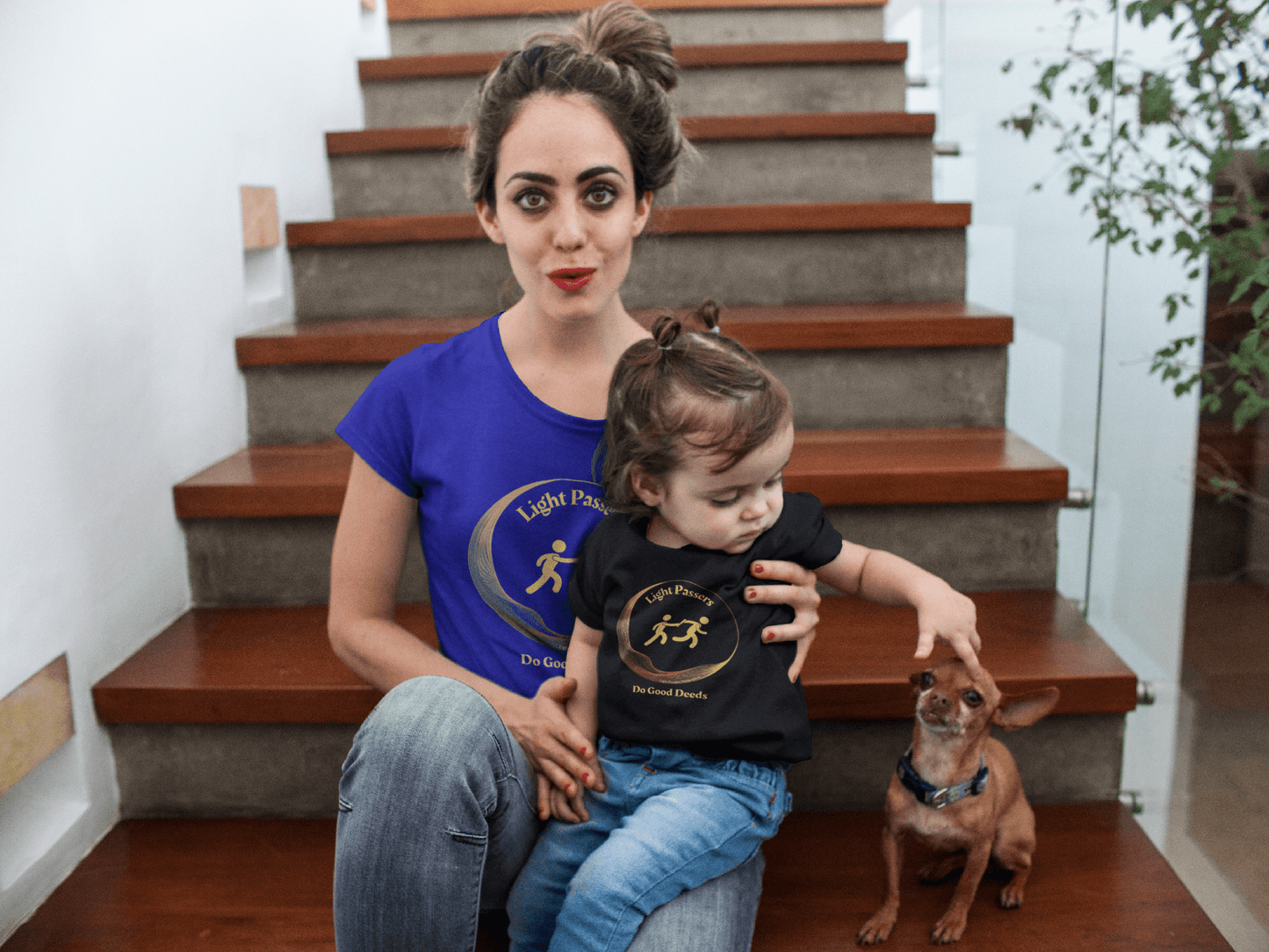 Toddler's Tee 'Do Good Deeds' Light Passers Relay Design, shown worn by a smiling toddler sitting with a woman on stairs, emphasizing comfort and cheerful design.
