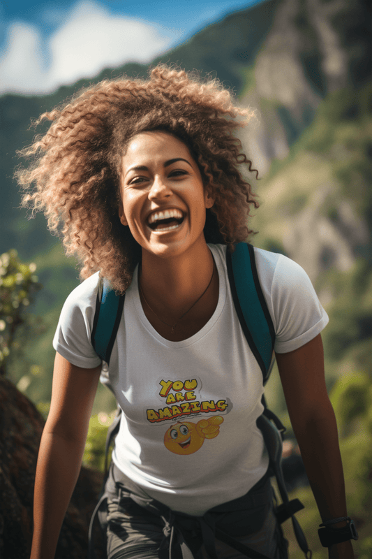 A woman with curly hair wearing a white shirt with a cartoon character, smiling and pointing at a sign, showcasing the You are Amazing emoji pointing Unisex T-Shirt's versatile style and comfort.