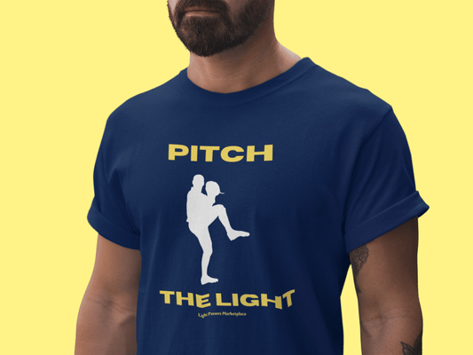 A man in a blue shirt featuring a baseball player design, showcasing the PITCH THE LIGHT yellow lettering Unisex T-Shirt. Made of soft 100% cotton with twill tape shoulders for durability and a ribbed collar.