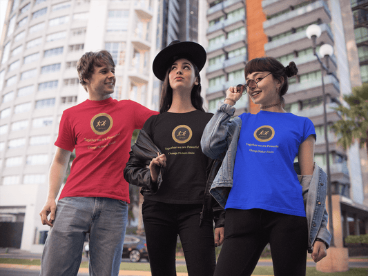 Three young adults showcase the Empowerment Tee with gold logo and inspirational text, embodying unity and empowerment, in an urban setting with palm trees.