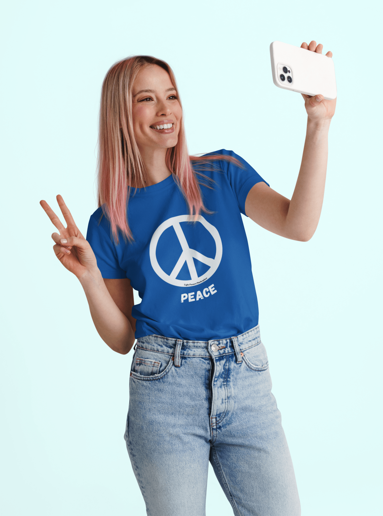 Woman in a blue Love and Peace Black or White Peace Sign Adult Unisex T-Shirt, smiling and taking a selfie, showcasing the shirt's design and comfortable fit.