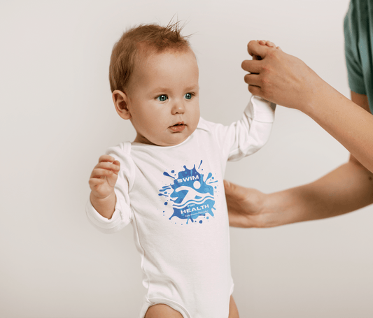 Baby in a Health Swim for Health Long Sleeve Onesie, showcasing ribbed knit binding and plastic snaps, held by a person.