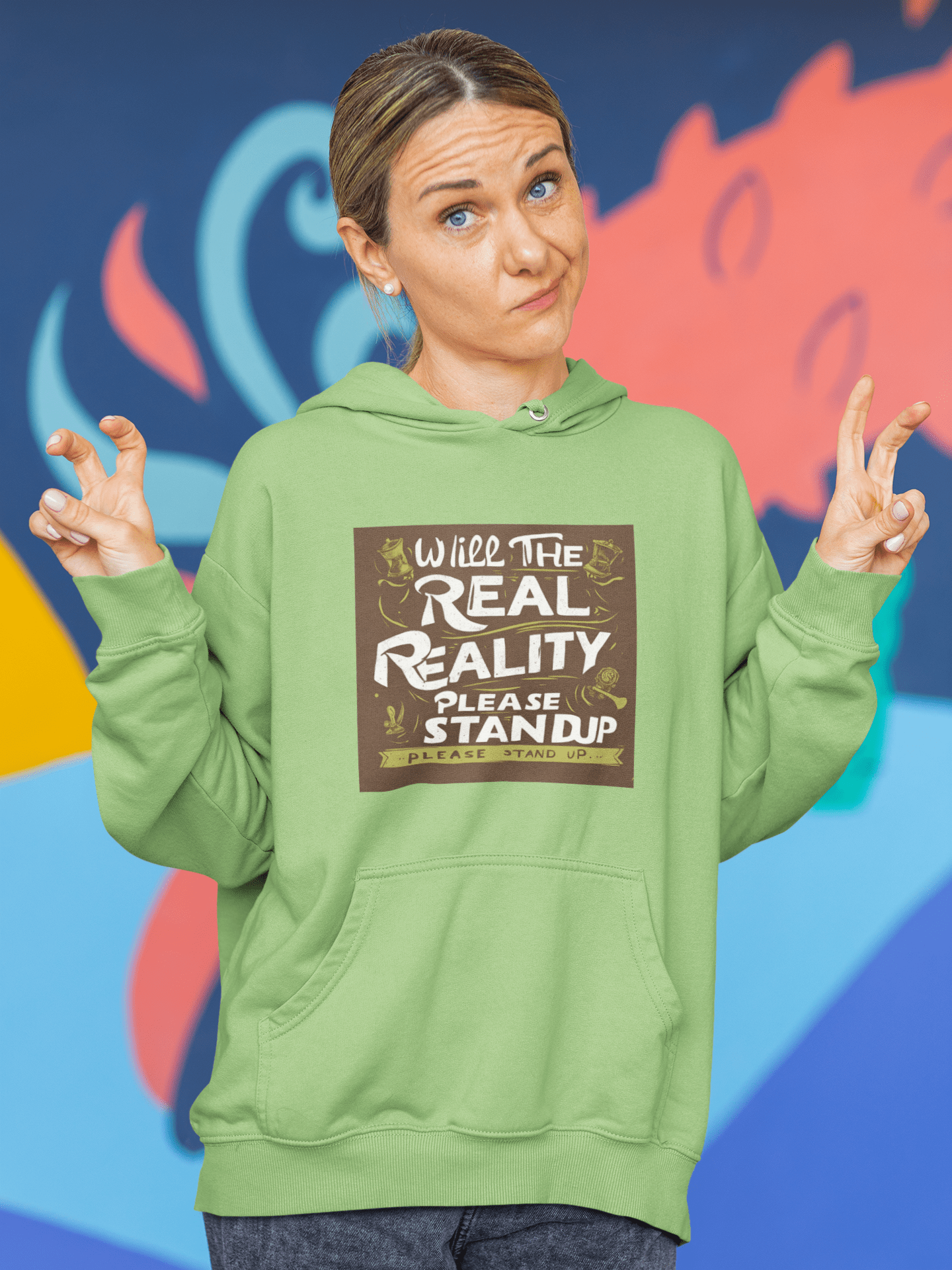 Person in a Will the Real Reality Please Stand Up hoodie, striking a thoughtful pose against a vibrant mural, embodying the store's inspirational ethos.