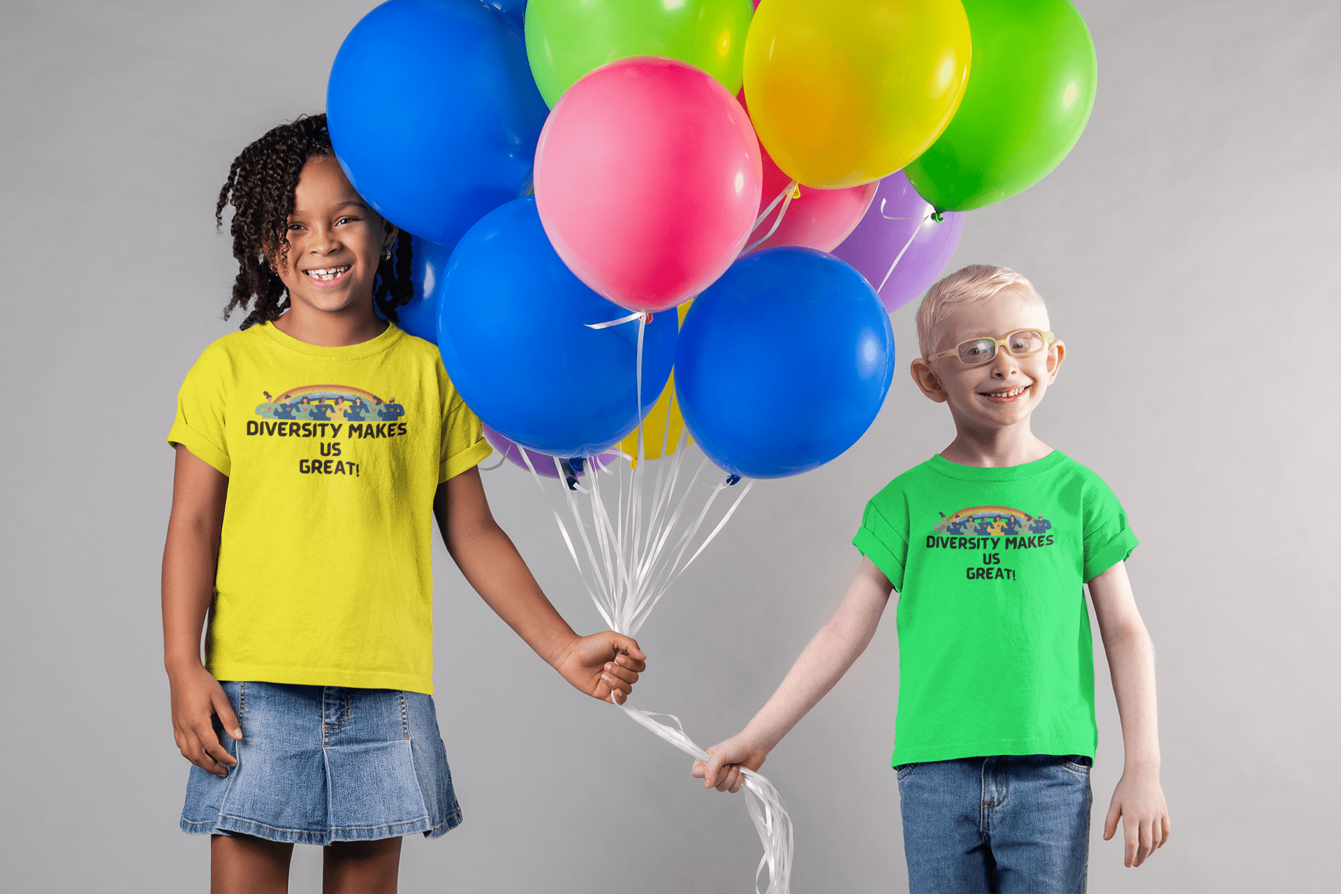 A boy and girl holding balloons, a girl smiling, and a boy in a green shirt with balloons. A soft, durable Diversity Makes Us Great Toddler T-shirt in 100% combed cotton, perfect for sensitive skin.
