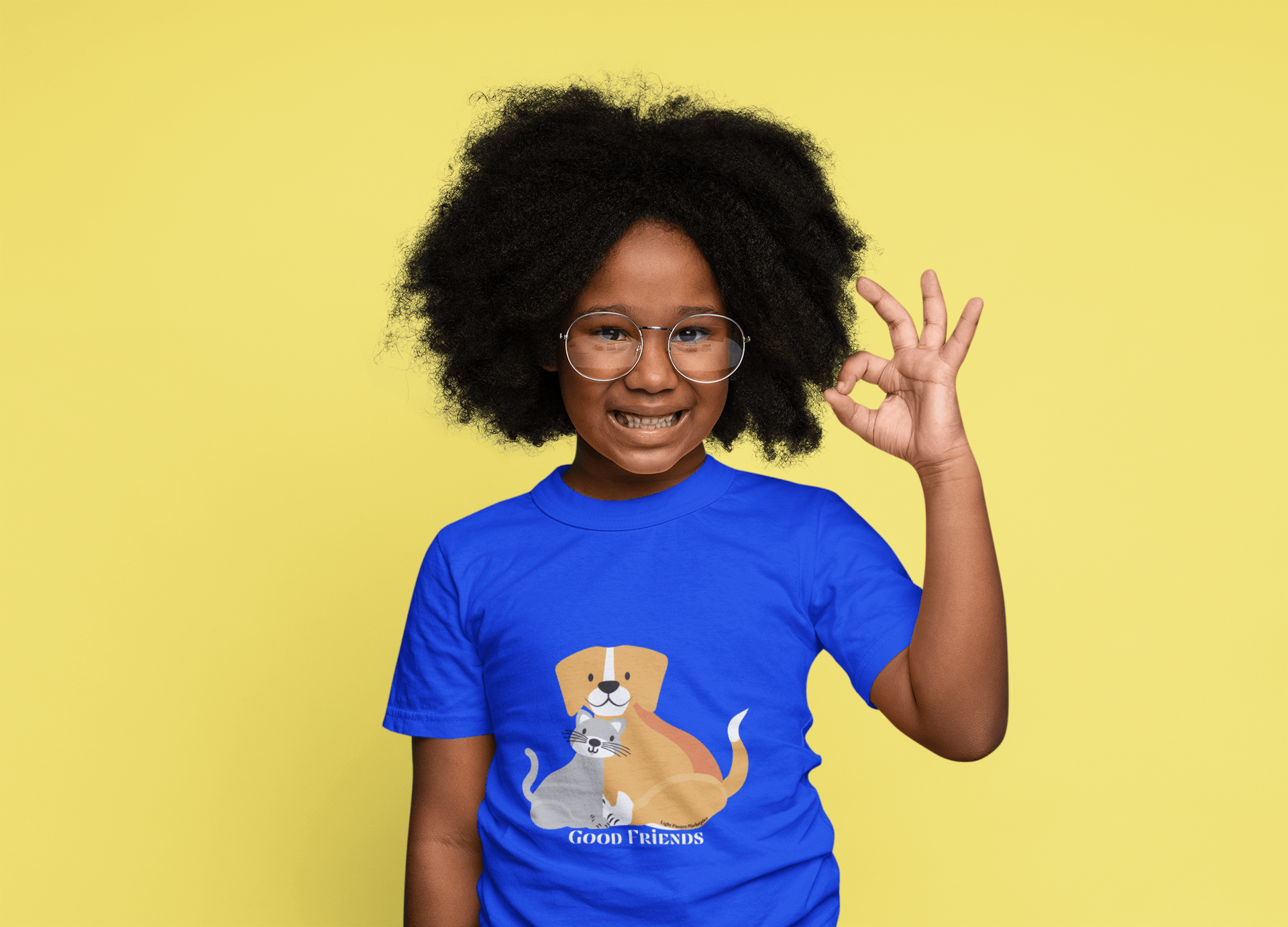 A toddler wearing glasses and a blue shirt, with a dog and cat graphic tee. Soft, durable 100% combed cotton, light fabric, tear-away label, classic fit.